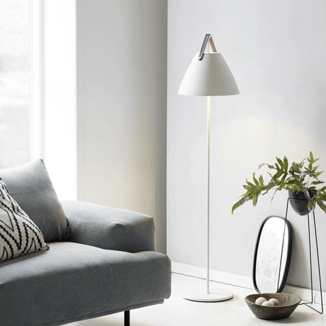 Witte staande lamp Nordlux Strap design lamp naast bank